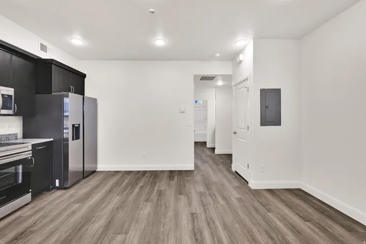 Modern kitchen featuring dark cabinetry, stainless steel appliances, and granite-style countertops