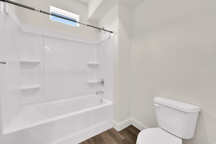 Bathroom featuring a white tub with integrated shelving, chrome fixtures, and a shower curtain rod