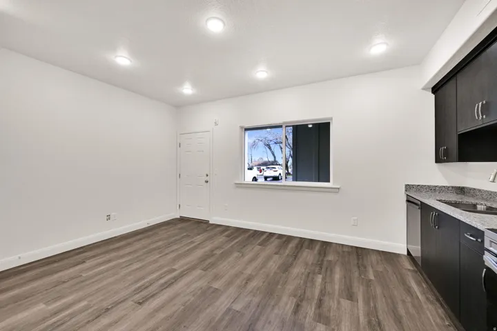 Open-concept living space featuring wood-finish flooring, recessed lighting, and white walls