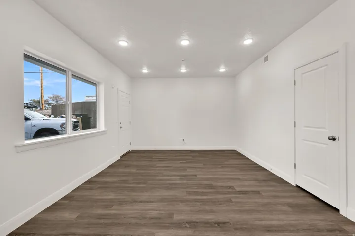 Spacious room featuring wood-finish flooring, recessed lighting, and a large window