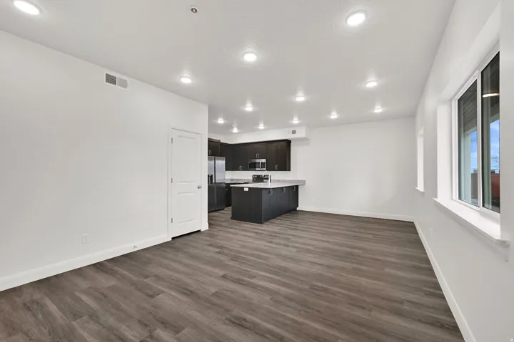Open-concept living space featuring wood-finish flooring, recessed lighting, and white trim