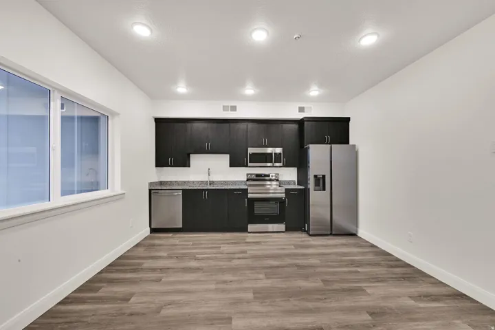 Kitchen featuring dark wood-finish cabinetry, stainless steel appliances, and light-toned countertops