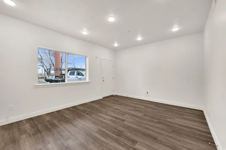 Open-concept room featuring wood-finish flooring, white baseboards, and neutral wall paint