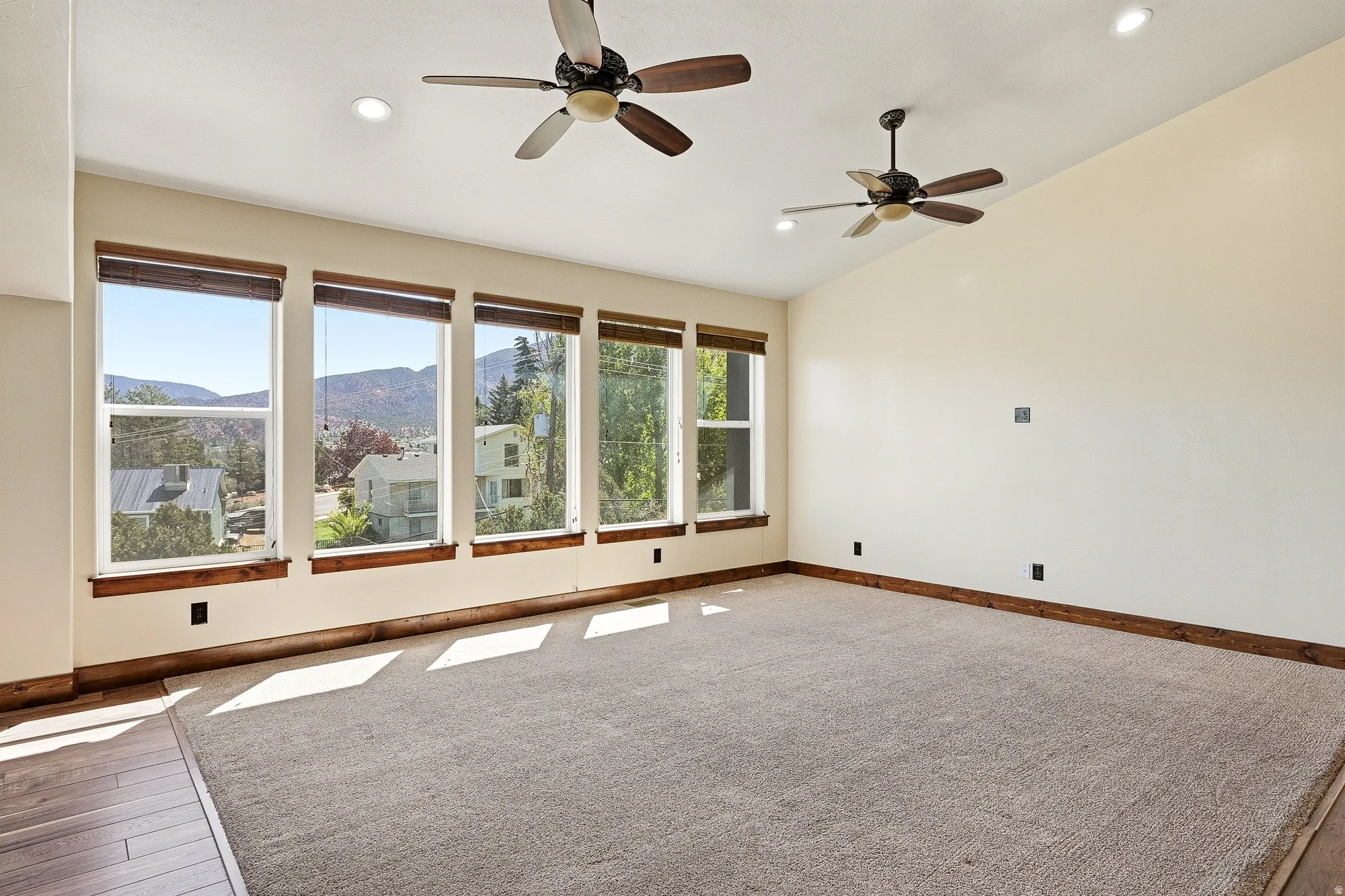 Spacious interior featuring a series of large windows, vaulted ceilings, and recessed lighting