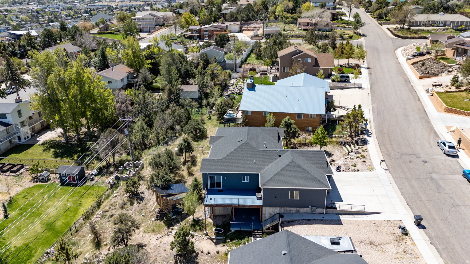 Contemporary multi-level residence featuring a dark gray shingle roof and blue siding