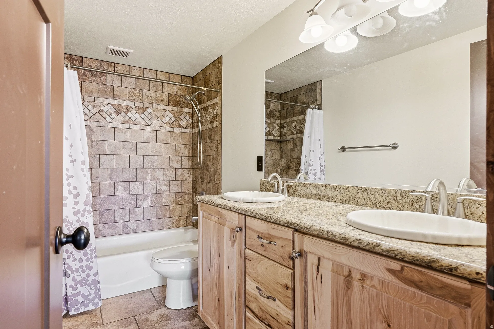 Bathroom featuring a double vanity with stone countertops and two undermount sinks