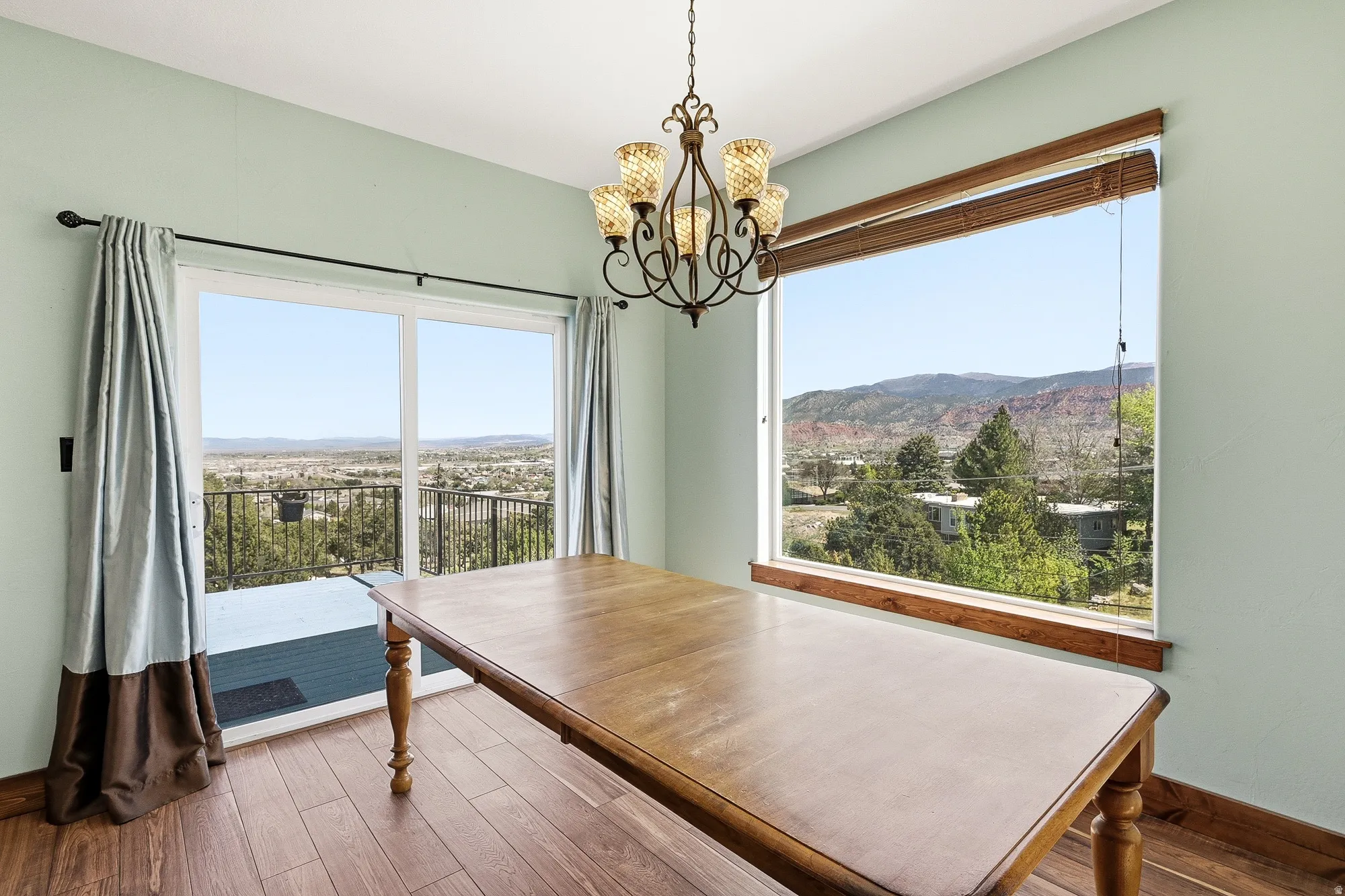 Expansive window and sliding glass door offering mountain and city scenery