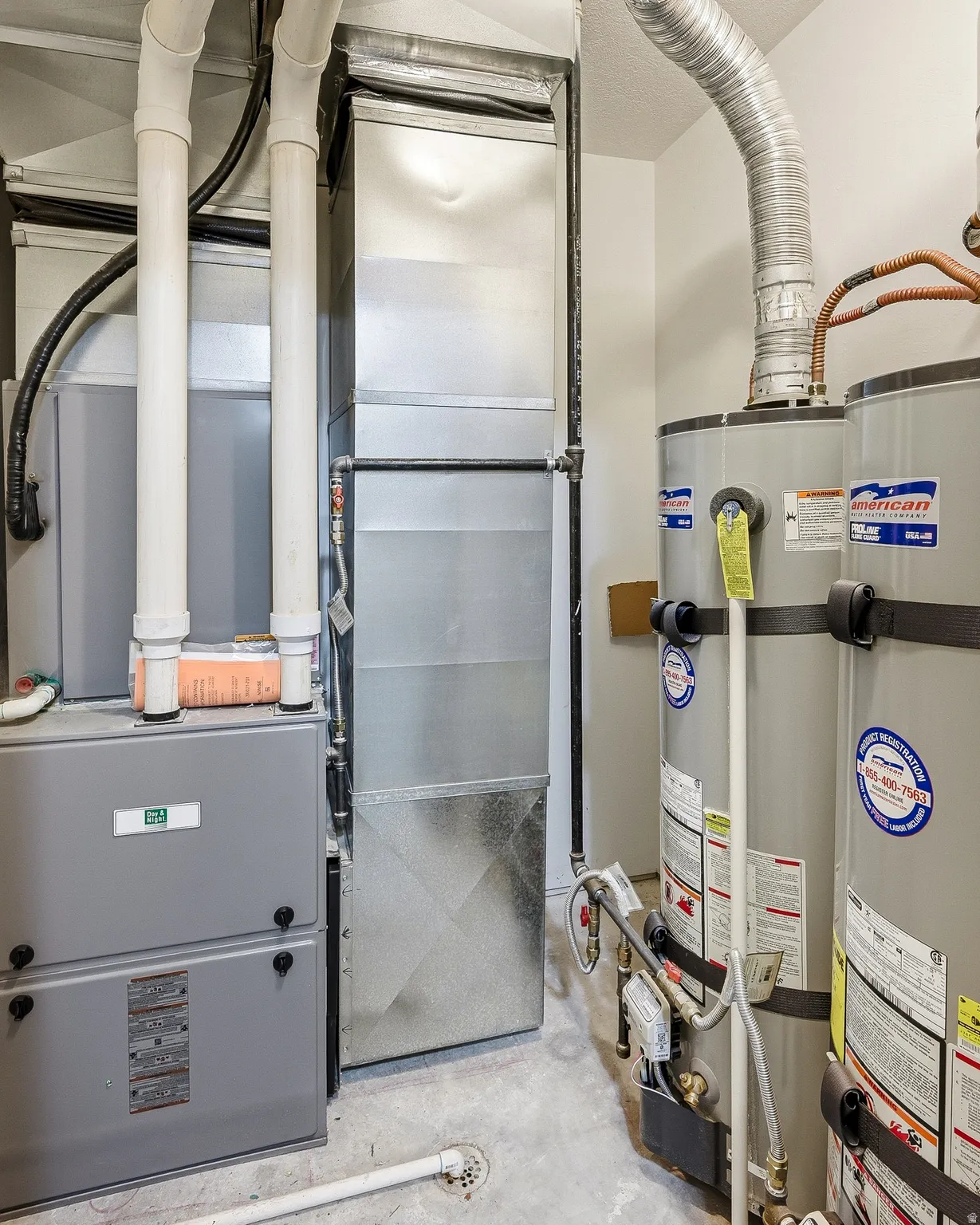 Dedicated utility space featuring dual water heaters and a furnace system