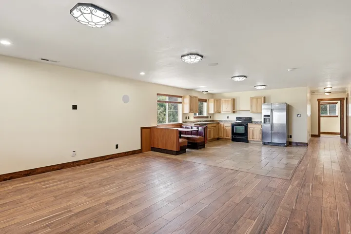 Open-concept living area featuring wood-finish flooring, recessed lighting, and a defined kitchen space