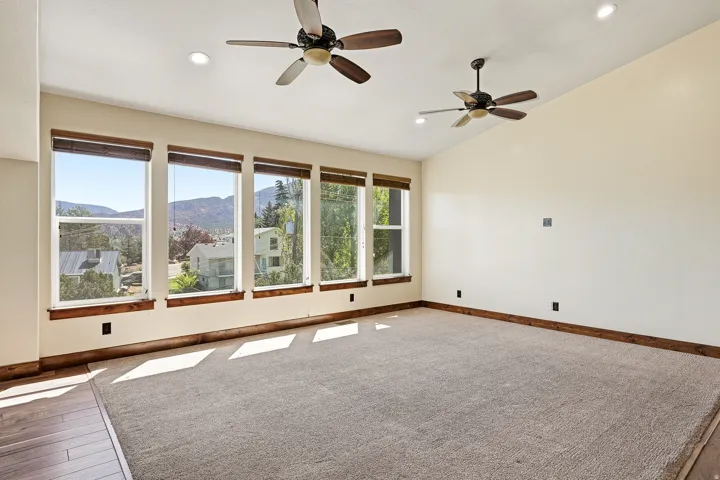 Spacious interior featuring a series of large windows, vaulted ceilings, and recessed lighting