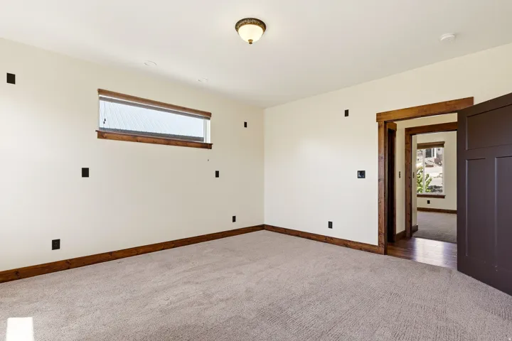 Carpeted room featuring a horizontal window with a blind, recessed lighting, wood-finish trim, and a solid-panel interior door