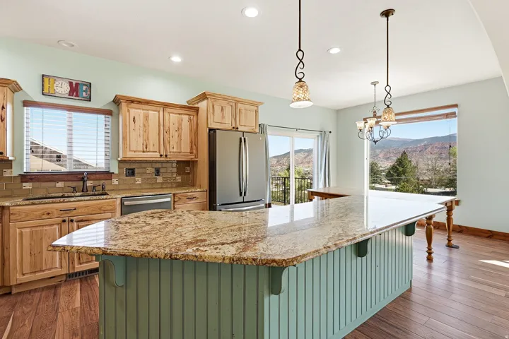 Kitchen featuring an expansive island with a granite countertop and beadboard base