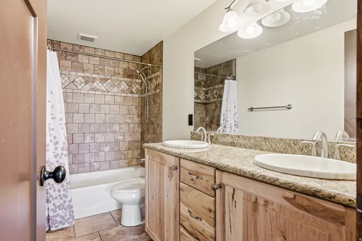 Bathroom featuring a double vanity with stone countertops and two undermount sinks