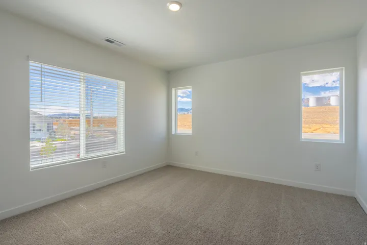 Recessed lighting, light-toned carpeting, multiple windows with blinds, and white wall finishes