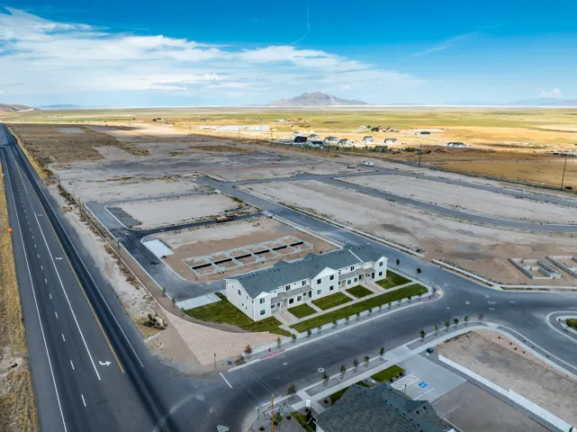 Modern townhome construction with multiple units, manicured green spaces, and paved roadways