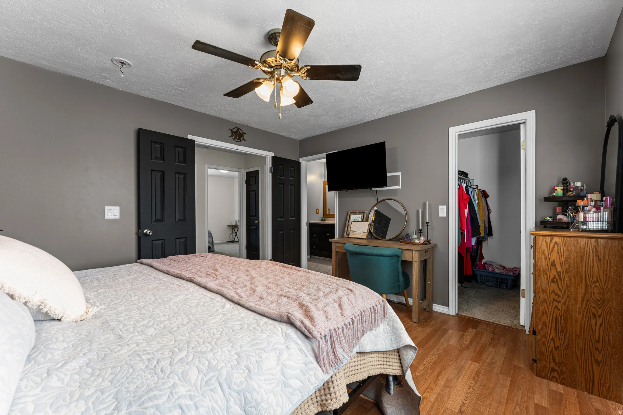 Bedroom featuring dark gray walls and wood-finish flooring