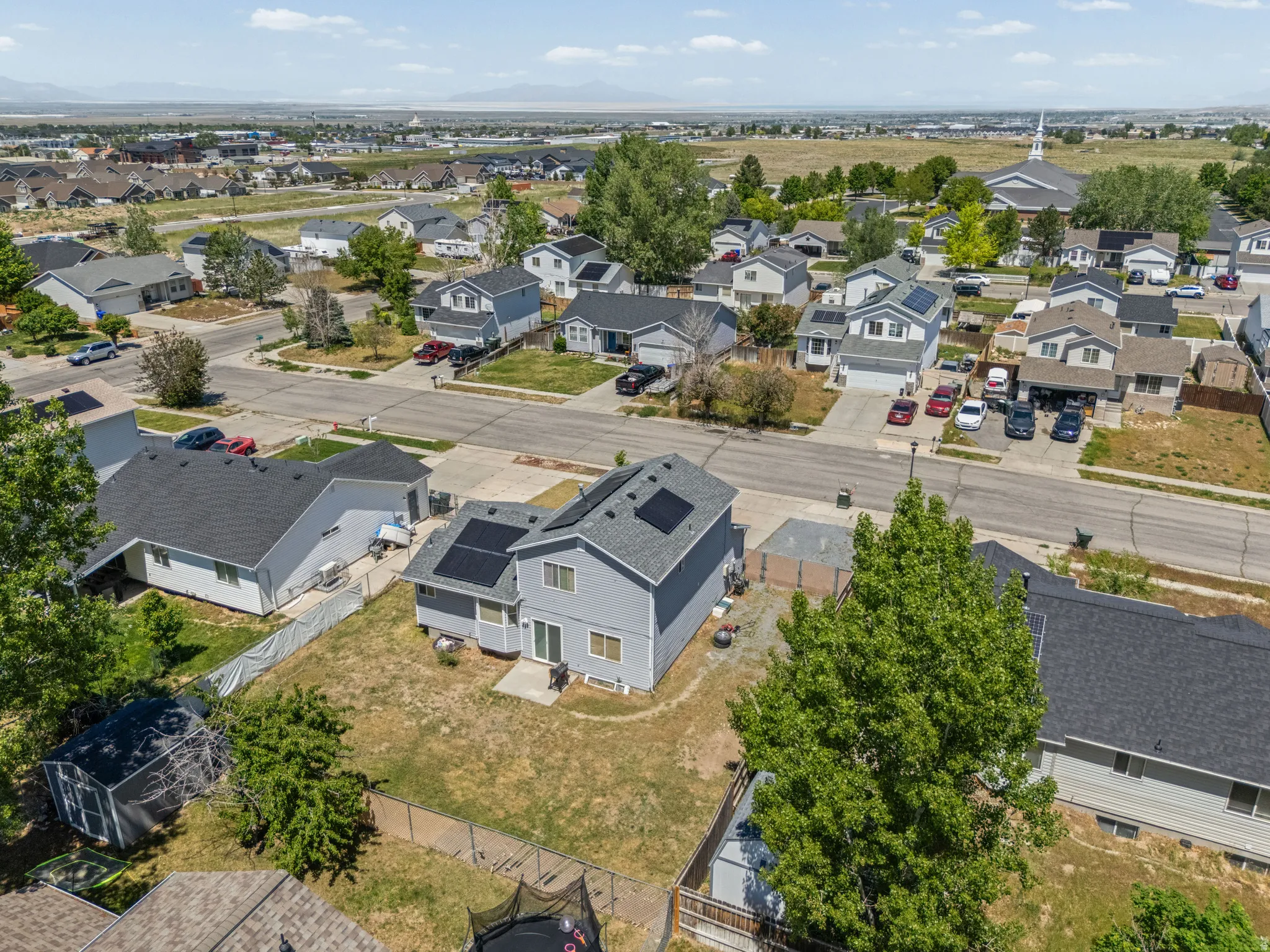 Aerial perspective showcasing a residential neighborhood with suburban homes and mountain scenery in the distance
