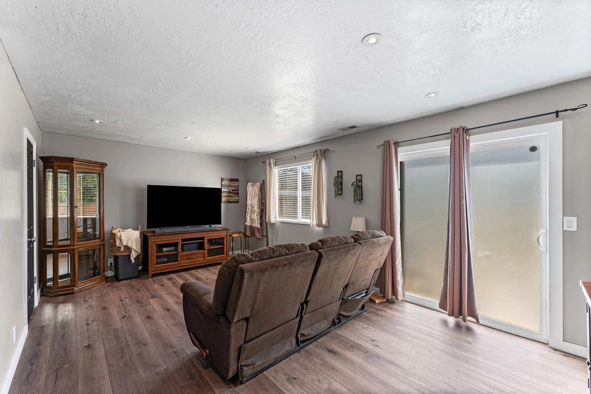 Living area with wood-finish flooring, recessed lighting, and a neutral wall palette
