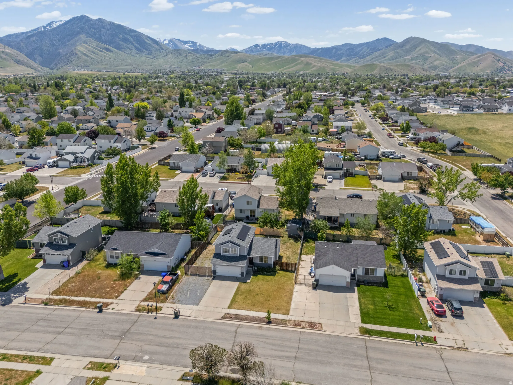 Aerial overview of a residential neighborhood with mountain backdrops