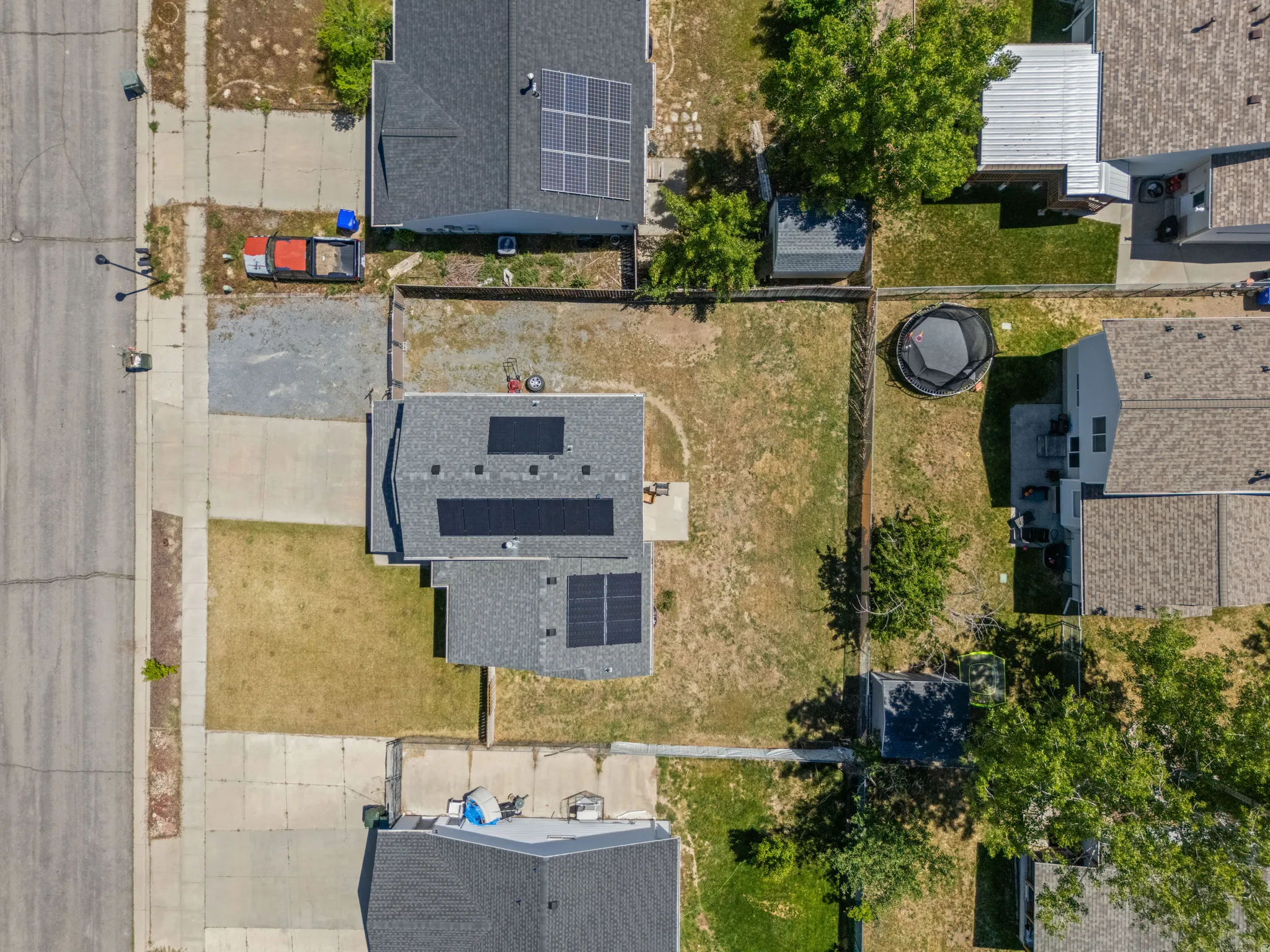 Property features a dark shingle roof with multiple solar panel installations