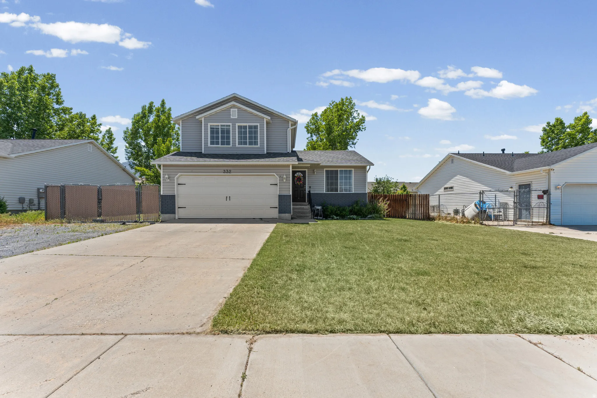 Split-level home featuring horizontal siding, a two-car garage, and a concrete driveway