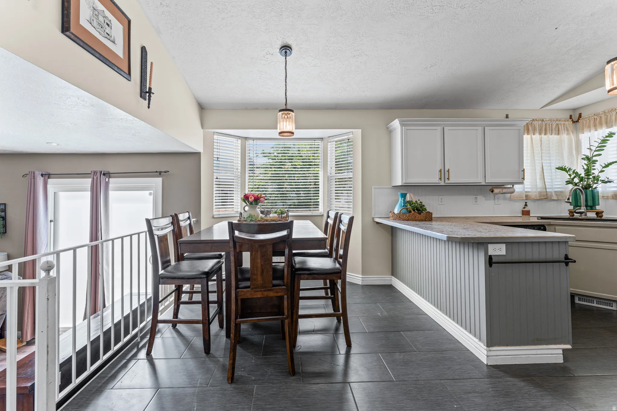 Open-concept kitchen and dining area featuring dark tile flooring