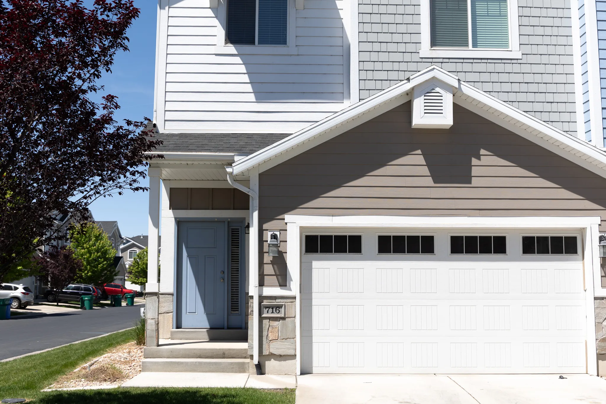Multi-level property exterior featuring white horizontal siding and gray shingle siding