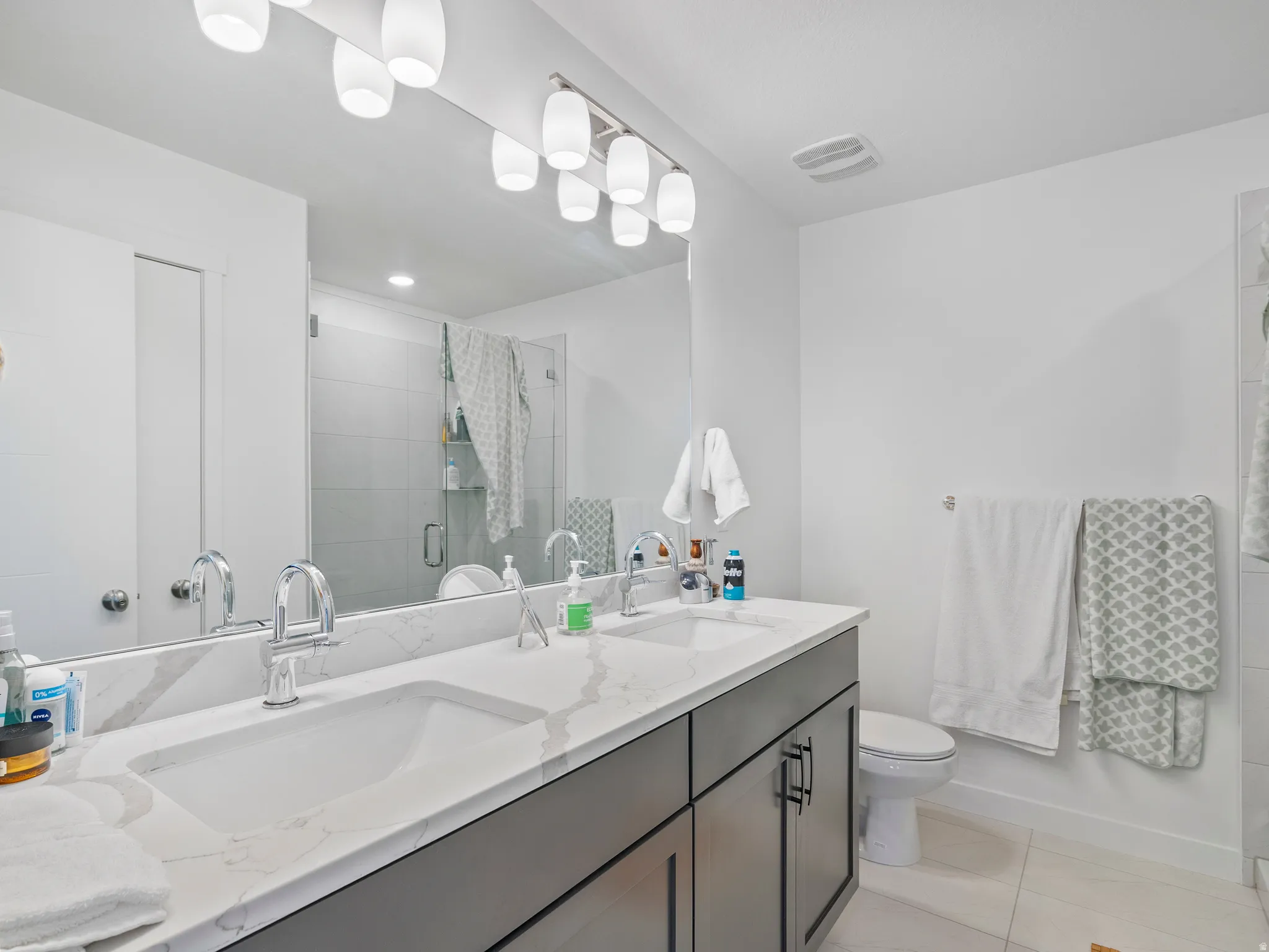 Double vanity with undermount sinks and a stone-finish countertop for main bathroom