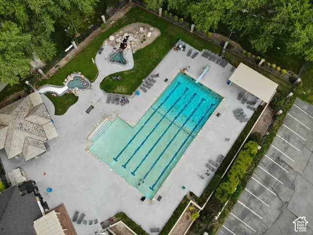 Community swimming pool featuring a diving board and shaded lounge areas
