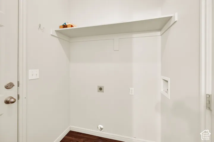 Dedicated utility area featuring a built-in white shelf, wood-finish flooring, and light-colored walls
