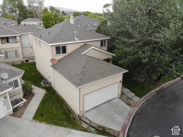 Two-story residence featuring light-toned stucco siding and a gray shingle roof