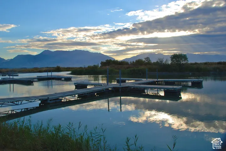 Waterfront setting featuring multiple boat docks, tranquil water, and distant mountain scenery