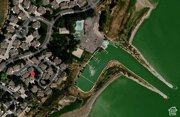Aerial perspective showcasing a residential neighborhood with proximity to a private marina