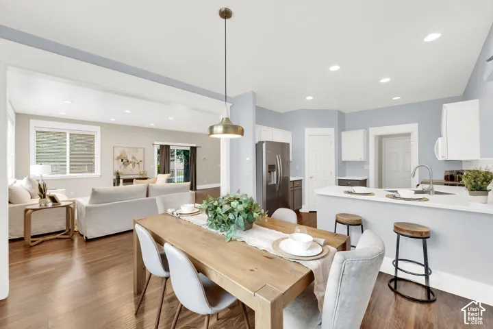 Open-concept living space featuring wood-finish flooring, recessed lighting, and a kitchen island with seating