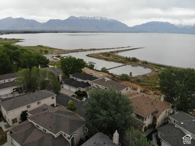 Aerial perspective showcasing a residential community situated along a large body of water, with distant mountains providing a scenic backdrop