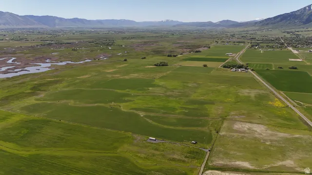 Expansive agricultural land featuring diverse green fields and distant mountain ranges