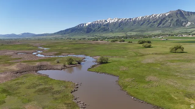 Expansive green landscape with a winding waterway