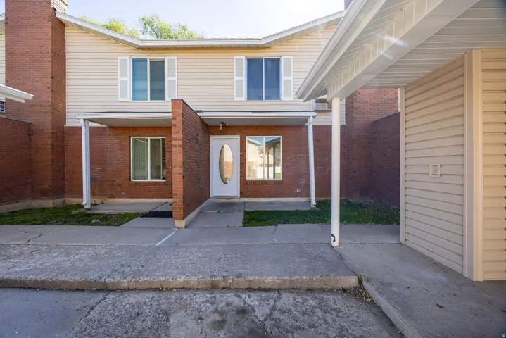 Two-story exterior featuring brick and horizontal siding, covered front entry, and white oval-lite front door