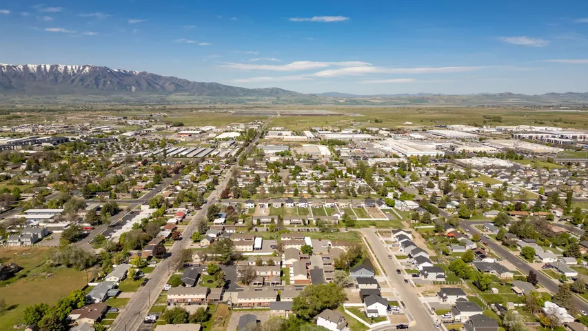 Expansive aerial perspective showcasing a residential district with a backdrop of snow-capped mountains