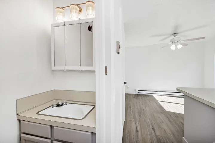 Bathroom vanity with integrated sink, tri-fold mirrored medicine cabinet, and three-light fixture