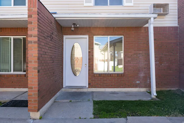 Red brick exterior with white trim and a covered entry