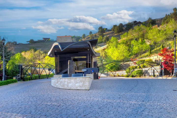 Stone paver driveway with a decorative metal gate and a contemporary entry structure