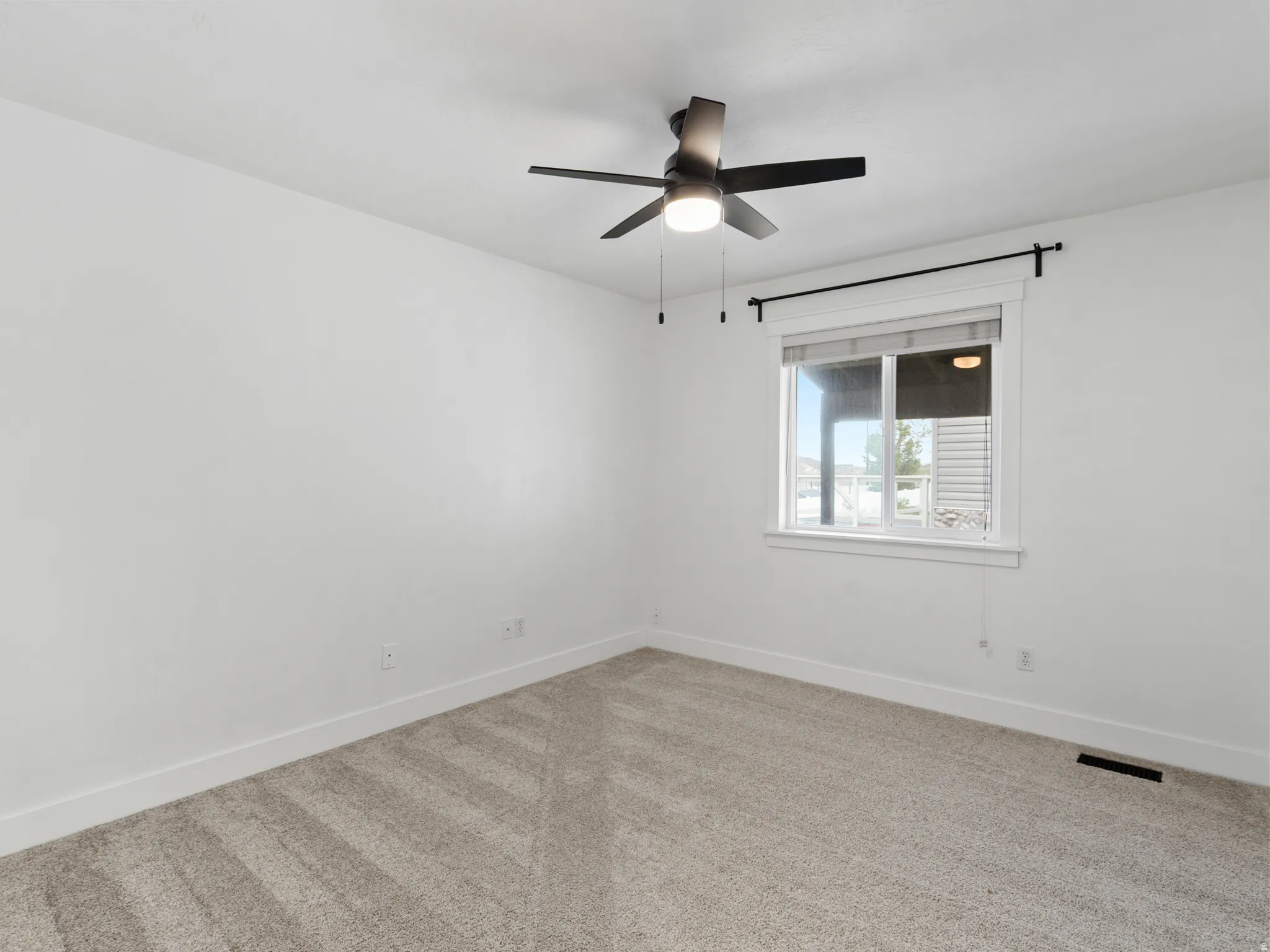 Neutral-toned wall-to-wall carpeting complements bright white walls and trim