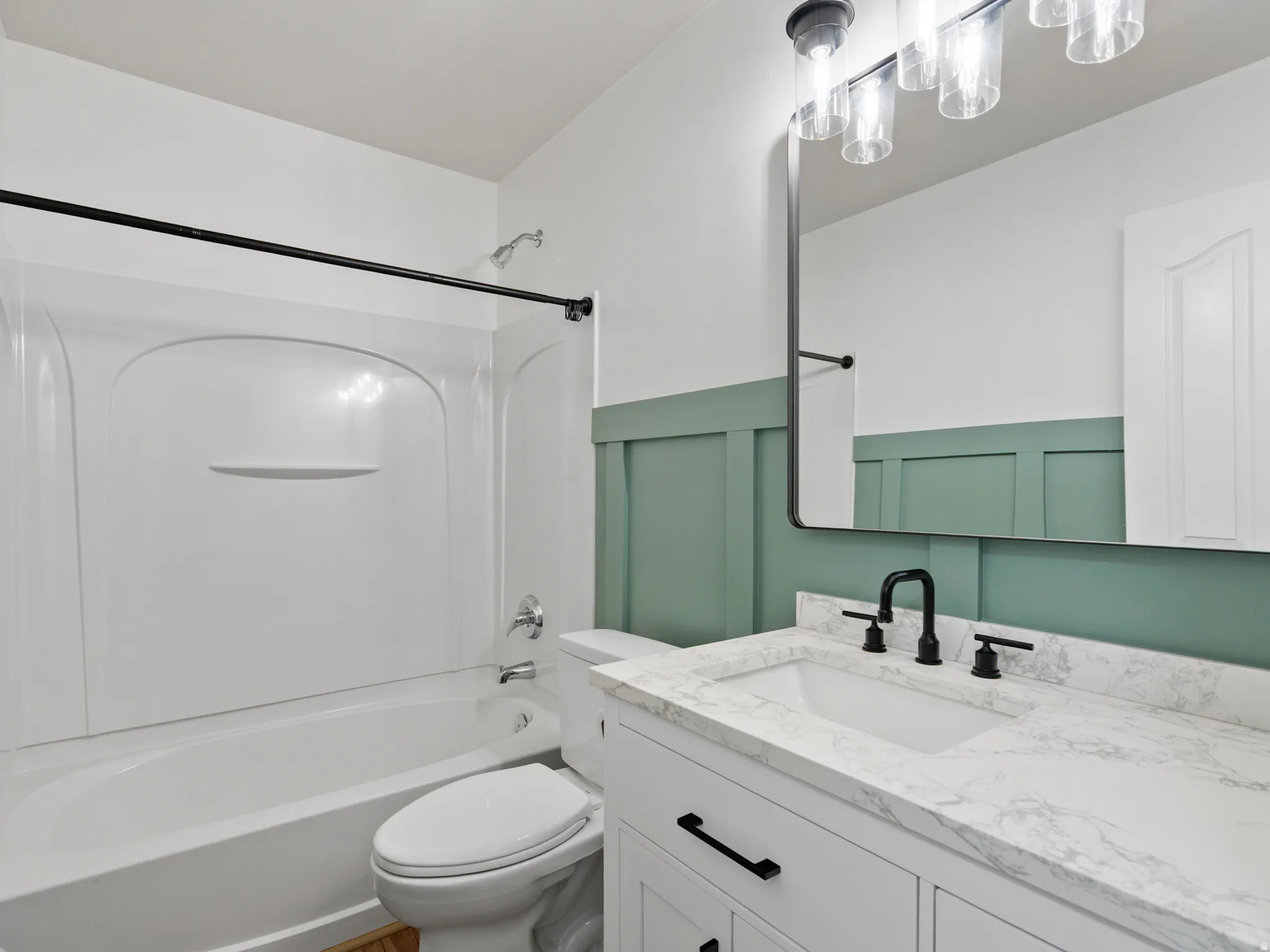 Bathroom featuring a white vanity with a stone-finish countertop, undermount sink, and matte black fixtures