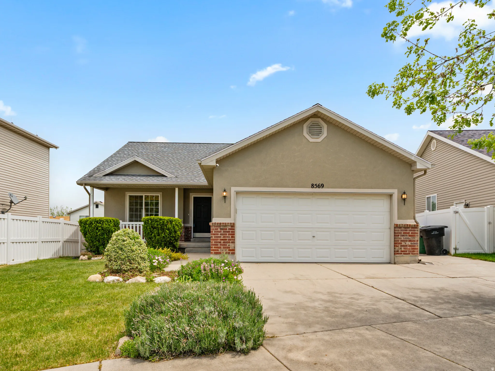 Contemporary stucco and brick-veneer exterior with an attached garage