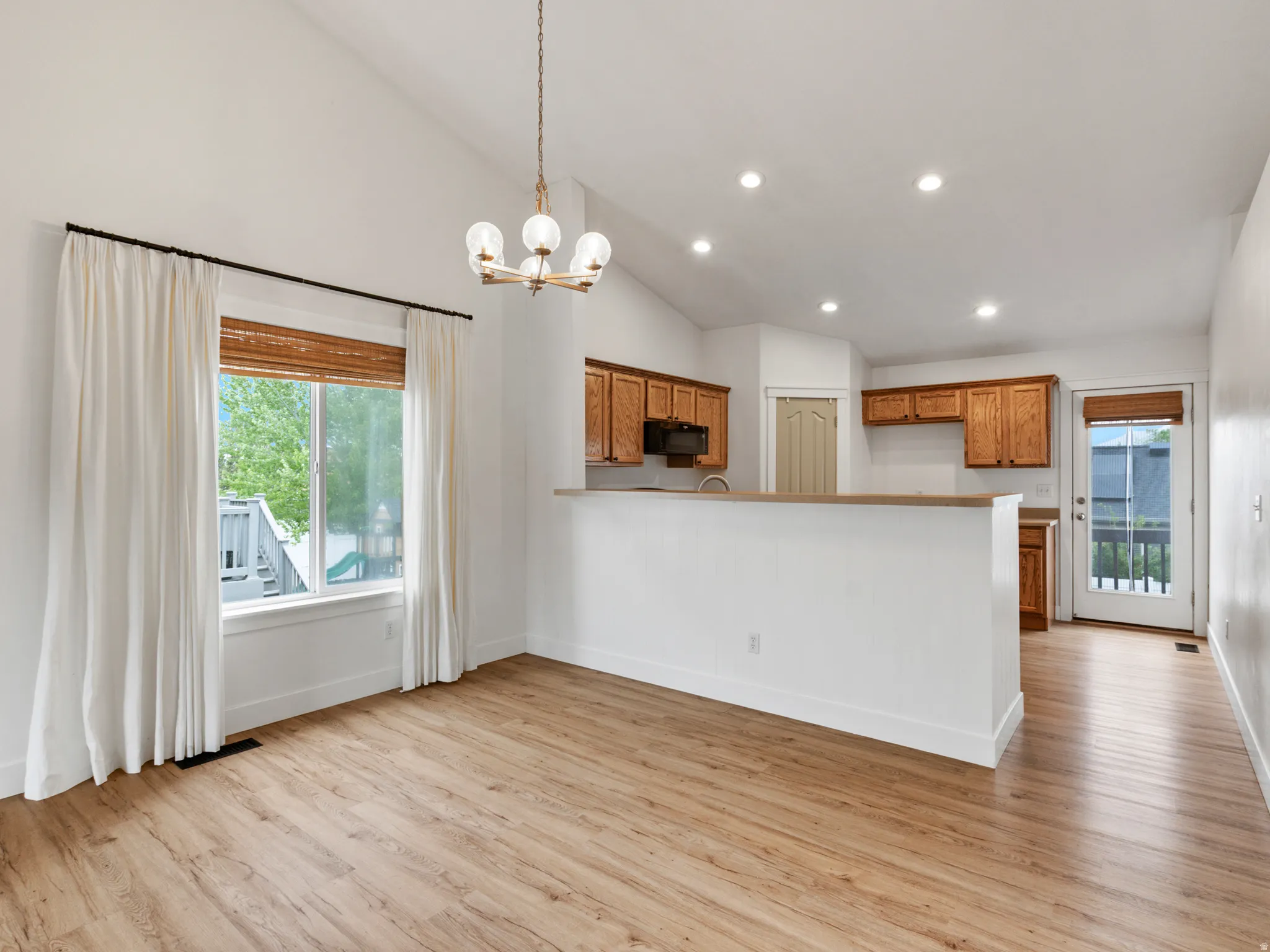 Vaulted ceilings complement the wood-finish flooring throughout this open-concept space