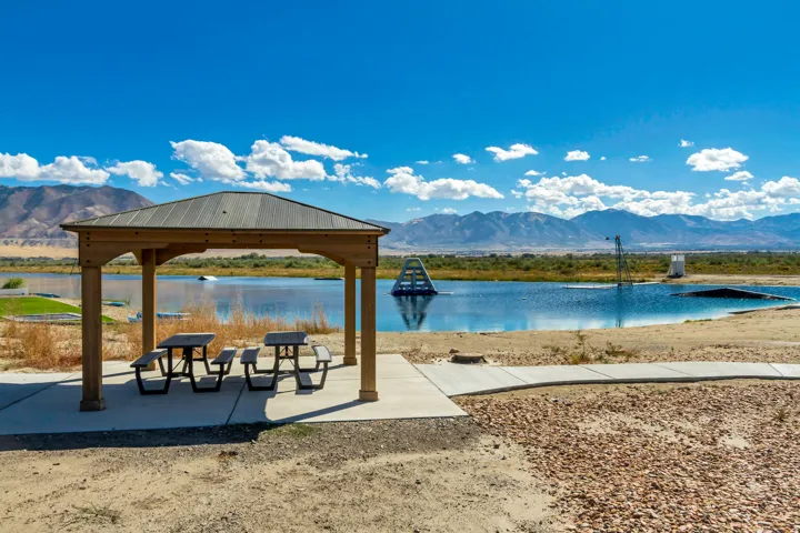 Wood-finish gazebo with a metal roof and two picnic tables on a concrete pad