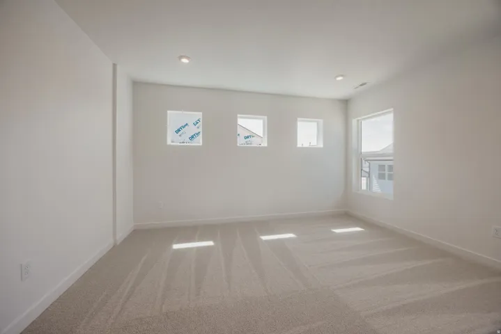 Spacious room featuring neutral carpeting and white baseboards