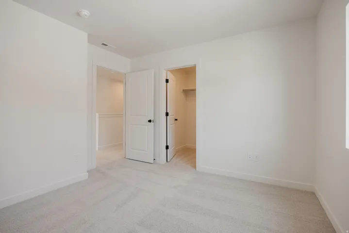 Neutral-toned wall-to-wall carpeting throughout