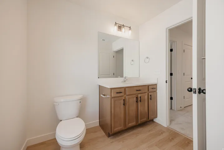 Bathroom featuring a single vanity with wood-finish cabinetry, a white countertop, and a rectangular sink